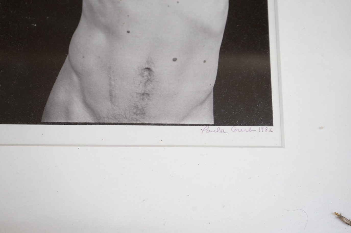 Paula Court - photographic silverprint, man taking T-shirt off, dated 1982, and three other photographs relating to the 1980’s downtown New York artscene, the first 23x15cm. Condition - fair.